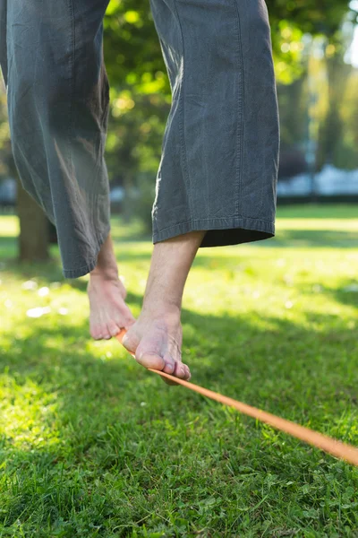 Ο άνθρωπος εν ενεργεία slack line στο πάρκο — Φωτογραφία Αρχείου