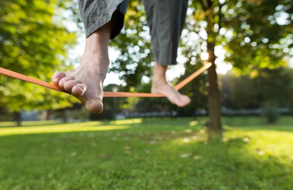 Ο άνθρωπος εν ενεργεία slack line στο πάρκο — Φωτογραφία Αρχείου