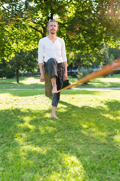 Man practising slack line in park — Stock Image Man practising slack line in park Stock Photo