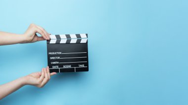 Woman holding movie clapper clipart