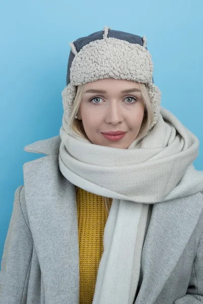 Kvinna i en ullig vintermössa med öronlappar — Stockfoto