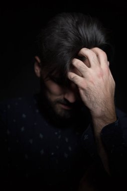 Karanlık arka plandaki genç adam.