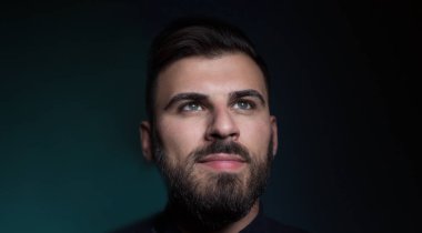 Karanlık arka plandaki genç adam.