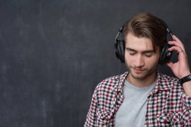 Müzik dinleyen genç bir adamın portresi.