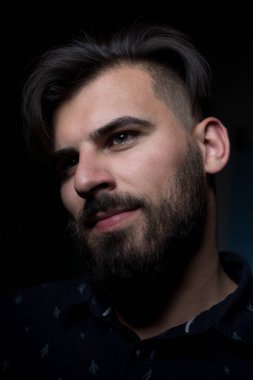 Karanlık arka plandaki genç adam.