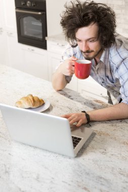 Dizüstü bilgisayar kullanarak sırasında kahvaltı adam
