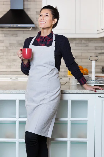 在她的厨房里喝咖啡的女人 — 图库照片