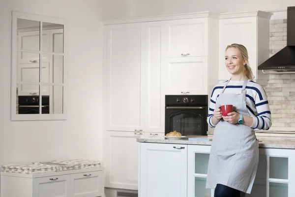 Woman drinking coffee in her kitchen — Stock Photo, Image