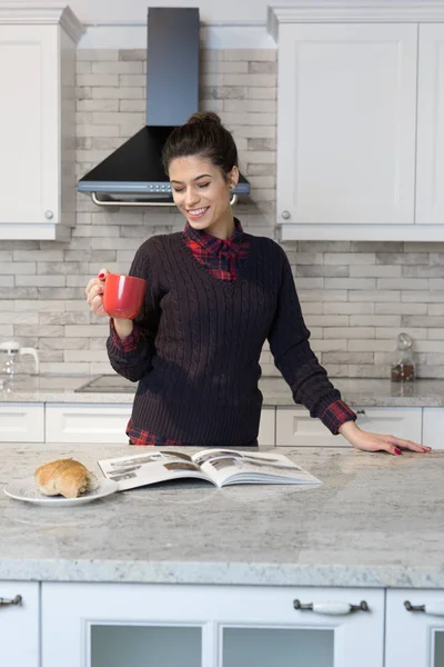 Femme buvant du café dans sa cuisine — Photo