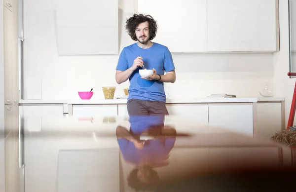 Man eating cereal in kitchen — Stock Photo, Image