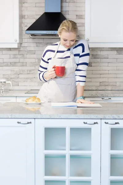 Donna che beve caffè nella sua cucina — Foto Stock