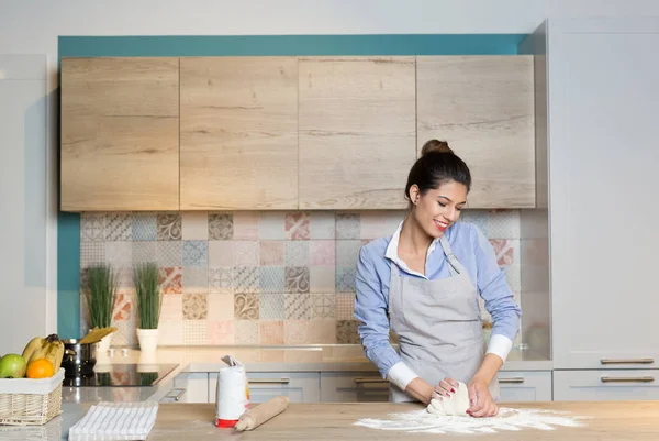 La giovane donna impasta la pasta a cucina — Foto Stock