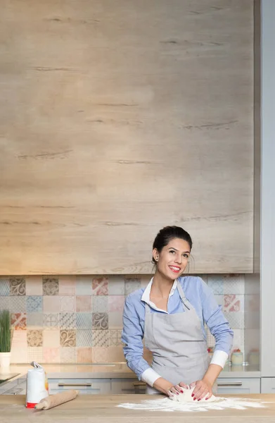 Jeune femme pétrir la pâte à la cuisine — Photo