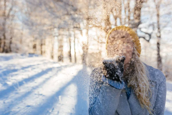 Genç kadın kar taneleri üfleme — Stok fotoğraf
