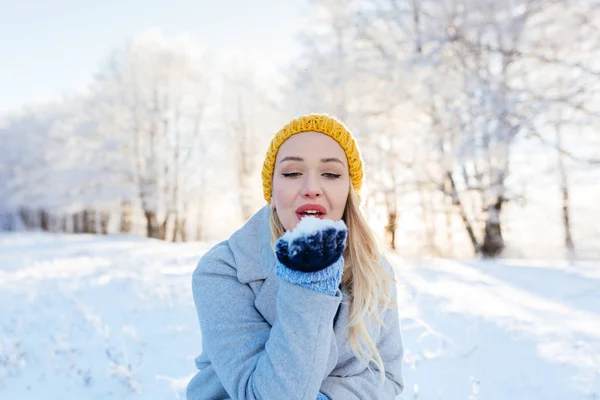 Mujer joven soplando copos de nieve — Foto de Stock