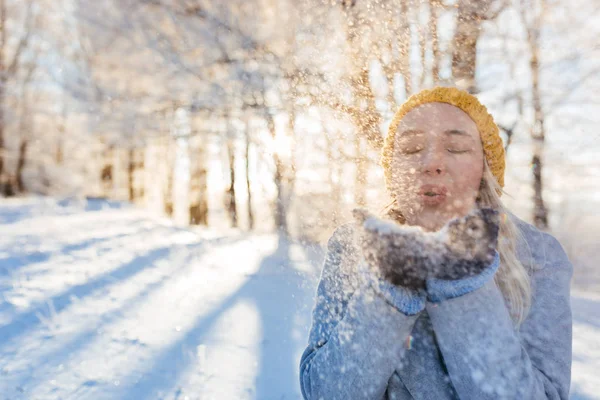 Giovane donna soffia fiocchi di neve — Foto Stock