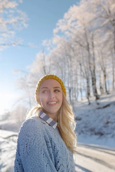 Симпатичная женщина, гуляющая в снежных горах — стоковое фото
