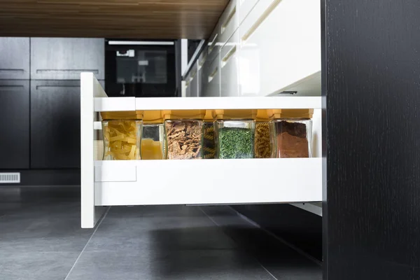 Специи и продукты, организованные в современном кухонном ящике — стоковое фото