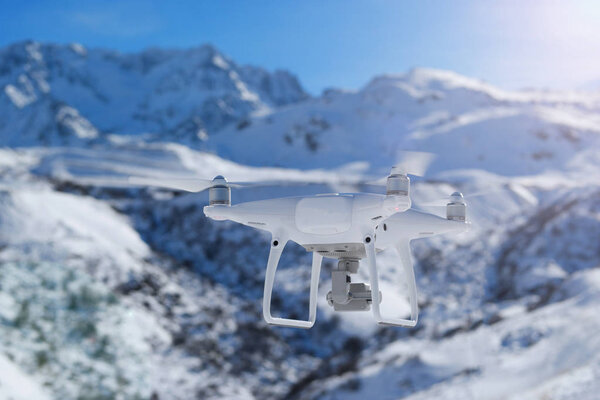 Летающий беспилотник в зимней горе
