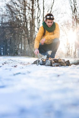 Genç adam kış ormanında