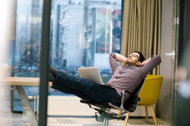 Genç adam ofiste çalışıyor.