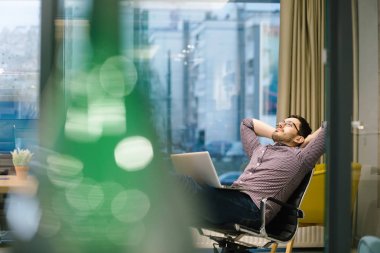 Genç adam ofiste çalışıyor.