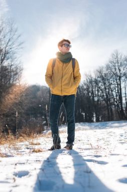 Genç adam kış ormanında