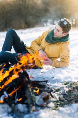 Genç adam kış ormanında