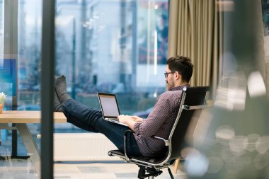 Genç adam ofiste çalışıyor.