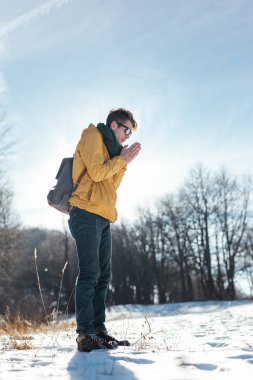 Genç adam kış ormanında