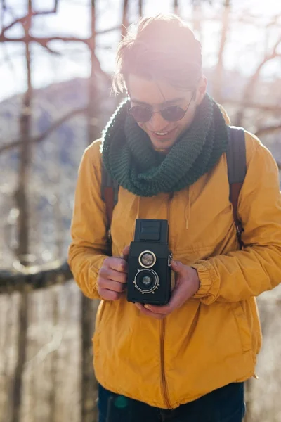 Uomo con fotocamera vintage nella foresta — Foto Stock