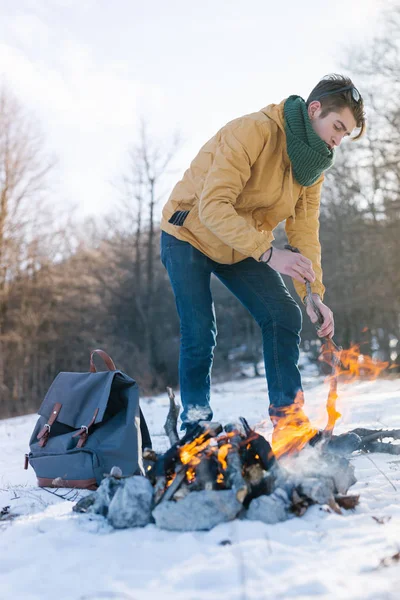 Genç adam kış ormanında