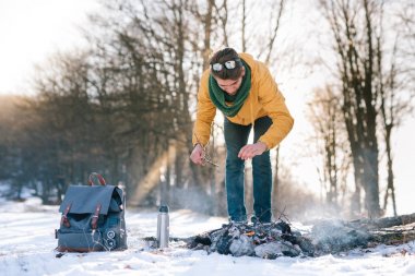 Genç adam kış ormanında