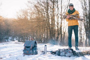 Genç adam kış ormanında