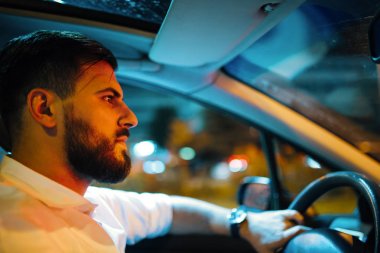Arabayı kullanan takım elbiseli ciddi iş adamı portresi kapatın. Yan görünüm