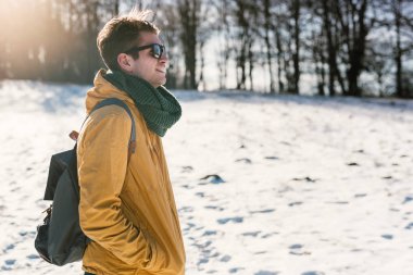 Genç adam kış ormanında