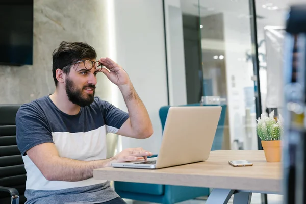 Homem de negócios barbudo trabalhando com laptop — Fotografia de Stock