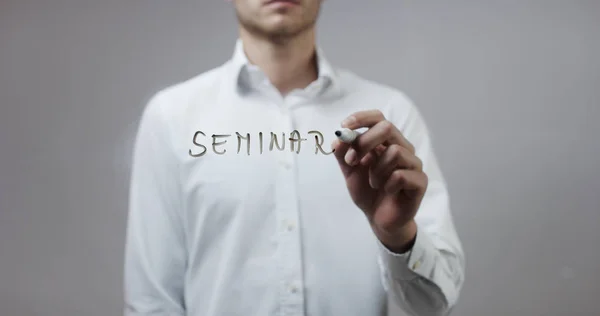 Young man writing on glass — Stock Photo, Image