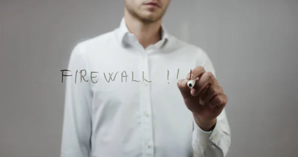 Young man writing on glass — Stock Photo, Image