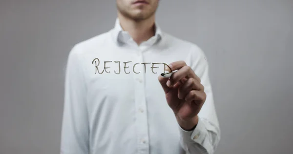 Young man writing on glass — Stock Photo, Image