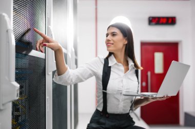 Sunucu odası içinde laptop üzerinde teknisyen portresi