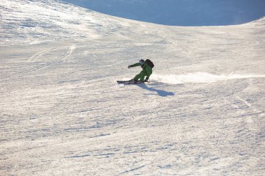 Çekici erkek kayakçı Rides yamaç aşağı A güneşli günde