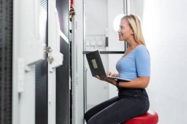 Sunucu odası içinde laptop üzerinde teknisyen portresi