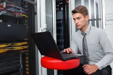 Süper bilgisayarla çalışma sunucu odası laptop ayakta tutan modern genç adam portresi
