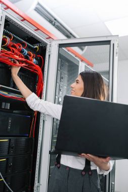 Sunucu odası içinde laptop üzerinde teknisyen portresi