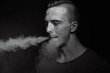 Erkekler siyah arka plan vaping ve Buhar bulutu serbest bırakır.