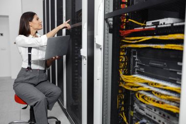 Sunucu odası içinde laptop üzerinde teknisyen portresi