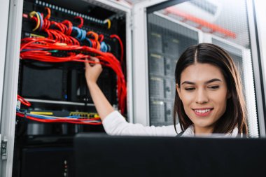 Sunucu odası içinde laptop üzerinde teknisyen portresi
