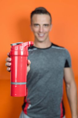 Bir kaşık protein tutan bir vücut geliştirmeciydi portresi karıştırmak içinde jimnastik salonu