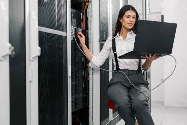 Sunucu odası içinde laptop üzerinde teknisyen portresi